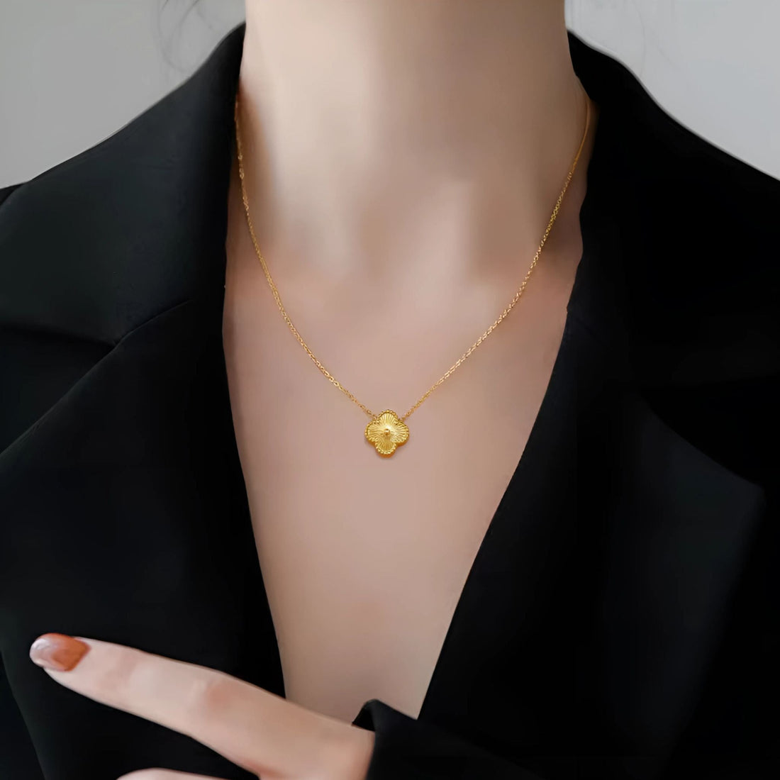 Woman wearing a clover pendant necklace with a light summer dress.