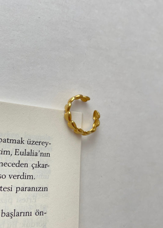 Hand mit mehreren vergoldeten Ringen im minimalistischen Stack-Look.